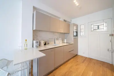 a kitchen with white cabinets and a white counter top at Luxury Apartment - 150m to Palais des Festivals ( Cannes ) in Cannes