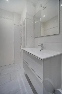 a white bathroom with a sink and a mirror at IMMOGROOM - Panoramic View - quiet - AC - bright in Cannes