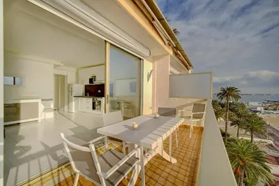 a balcony with a table and chairs and the ocean at IMMOGROOM - Panoramic View - quiet - AC - bright in Cannes