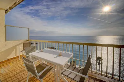 a balcony with a table and chairs and the ocean at IMMOGROOM - Panoramic View - quiet - AC - bright in Cannes