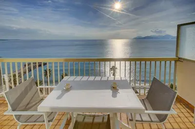 a white table and chairs on a balcony with the ocean at IMMOGROOM - Panoramic View - quiet - AC - bright in Cannes