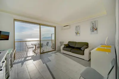 a living room with a couch and a balcony at IMMOGROOM - Panoramic View - quiet - AC - bright in Cannes