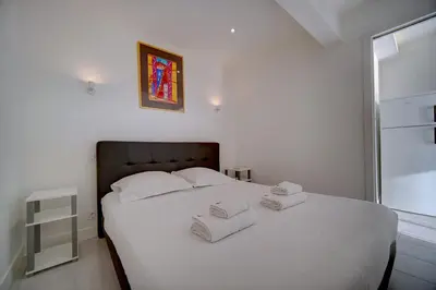 a bedroom with a white bed with towels on it at IMMOGROOM - Panoramic View - quiet - AC - bright in Cannes