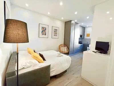 a bedroom with a bed with a lamp and a television at Brand-New 1 Bedroom Fully Refurbished in Cannes