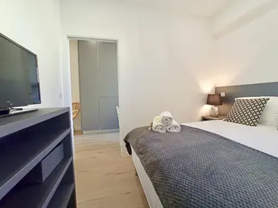 a bedroom with a bed and a flat screen tv at Brand-New 1 Bedroom Fully Refurbished in Cannes