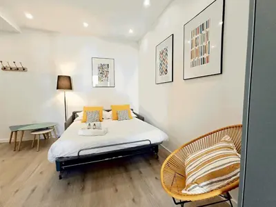 a bedroom with a bed and a table and chairs at Brand-New 1 Bedroom Fully Refurbished in Cannes