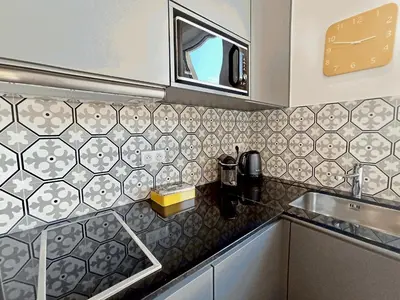 a kitchen counter with a sink and a mirror at Brand-New 1 Bedroom Fully Refurbished in Cannes