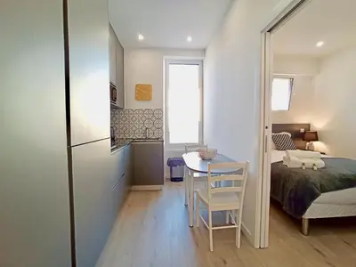 a small bedroom with a bed and a table and chairs at Brand-New 1 Bedroom Fully Refurbished in Cannes