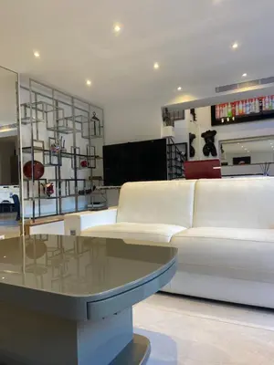 a living room with a white couch and a glass table at VILLA OCEANE in Cannes