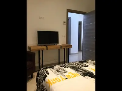 a bedroom with a bed and a desk with a television at VILLA OCEANE in Cannes