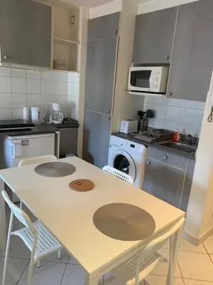 a kitchen with a table and chairs and a microwave at Studio CENTRE CROISETTE in Cannes