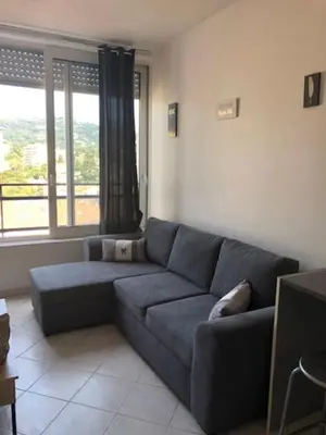 a living room with a couch and a large window at Studio CENTRE CROISETTE in Cannes