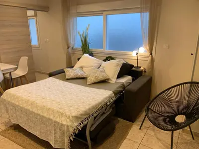 a bedroom with a bed and a table and a window at Cosy apartment + secured PARKING in Cannes