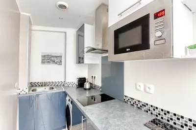 a kitchen with a sink and a microwave at Cosy apartment + secured PARKING in Cannes
