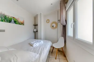 a small bedroom with a bed and a window at Cosy apartment + secured PARKING in Cannes
