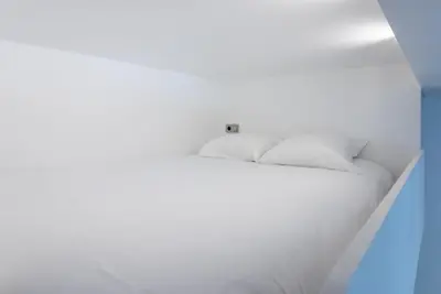 a white bed with white sheets and pillows at Studio Léa in Cannes
