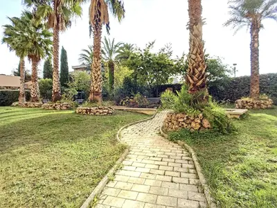 a brick path in a park with palm trees at Nicolas 8 in Cannes