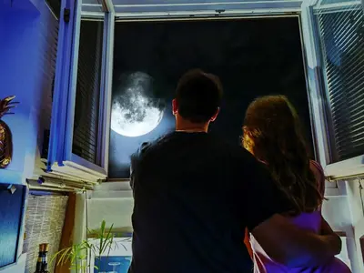 a couple looking out a window at the moon at CANNES TOIT ET MOI in Cannes