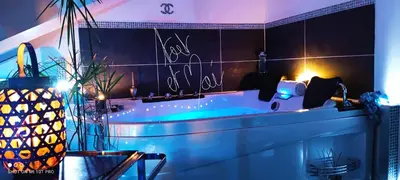 a bathroom with a tub with lights on the wall at CANNES TOIT ET MOI in Cannes