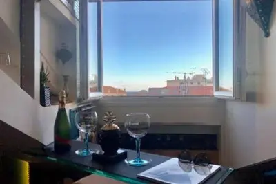 a table with two wine glasses and a window at CANNES TOIT ET MOI in Cannes