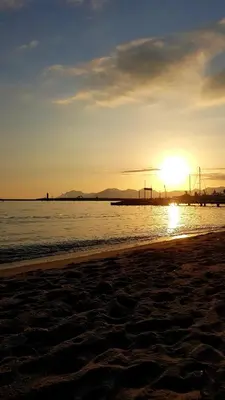 a sunset on a beach with the sun setting in the distance at CANNES TOIT ET MOI in Cannes