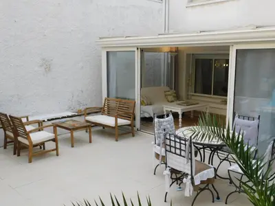 a patio with chairs and tables and a couch at Lovely 1 Bedroom Boulevard de la Croisette in Cannes