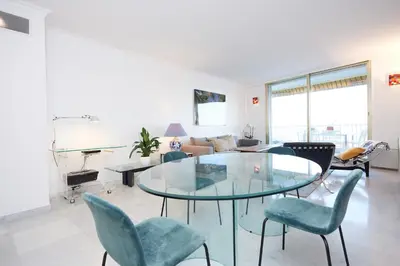 a living room with a glass table and chairs at Palm Beach Amazing view in Cannes