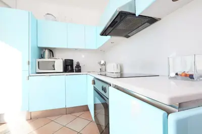 a kitchen with white cabinets and a microwave at Palm Beach Amazing view in Cannes