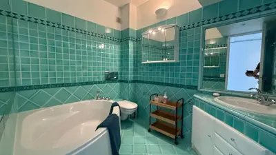 a green tiled bathroom with a tub and a sink at Palm Beach Amazing view in Cannes