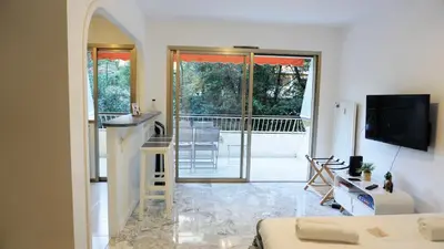 a room with a kitchen and a living room with a counter at Proche Croisette, Exclusivité Congres by Palmazur in Cannes