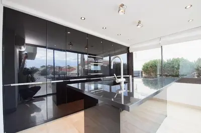 a kitchen with black cabinets and glass walls at Appartement privé vue mer Cannes centre Gray d'Albion in Cannes
