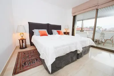 a bedroom with a large bed and a large window at Appartement privé vue mer Cannes centre Gray d'Albion in Cannes