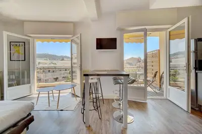 a bedroom with a bed and a desk and a balcony at Le Maria - Cannes - Renovated Feb 2025 in Cannes