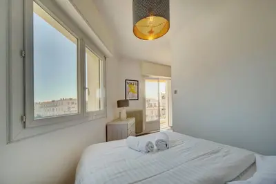 a bedroom with a large white bed with a window at Le Maria - Cannes - Renovated Feb 2025 in Cannes