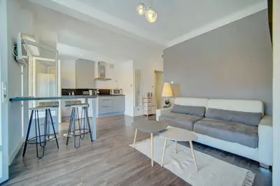 a living room and kitchen with a couch and a table at Le Maria - Cannes - Renovated Feb 2025 in Cannes