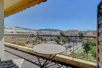a balcony with a table and a view of a city at Le Maria - Cannes - Renovated Feb 2025 in Cannes