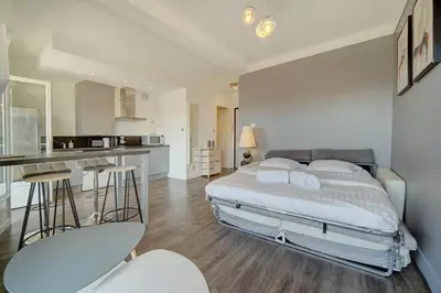 a bedroom with a large bed and a kitchen at Le Maria - Cannes - Renovated Feb 2025 in Cannes