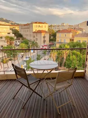 a table and chairs on a balcony with a view of a city at Le Maria - Cannes - Renovated Feb 2025 in Cannes