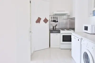 a white kitchen with a stove and a refrigerator at 1-Br Sea view Luxury Residential with pool in Cannes