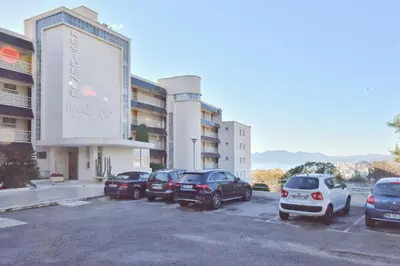 a parking lot with cars parked in front of a building at 1-Br Sea view Luxury Residential with pool in Cannes