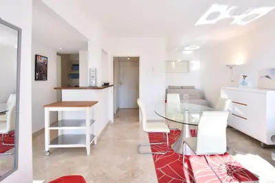a kitchen and living room with a glass table and white chairs at 1-Br Sea view Luxury Residential with pool in Cannes