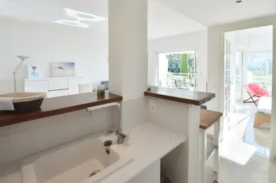 a white kitchen with a sink and a mirror at 1-Br Sea view Luxury Residential with pool in Cannes