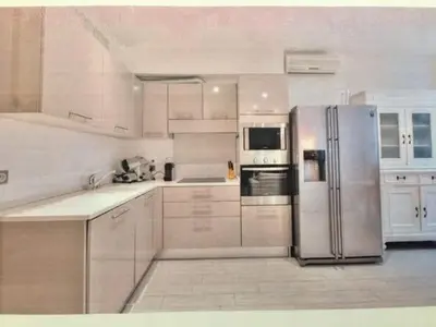 a kitchen with white cabinets and a stainless steel refrigerator at beautiful 3 room-flat near palais in Cannes