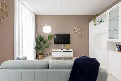 a living room with a couch and a tv at beautiful 3 room-flat near palais in Cannes