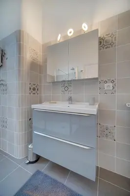 a bathroom with a white sink and a mirror at IMMOGROOM - Villa in the city center with terrace- garden in Cannes
