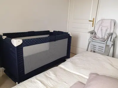 a bed in a room with a crib and a chair at Appartement duplex 6 personnes Cannes Grand Parc in Cannes