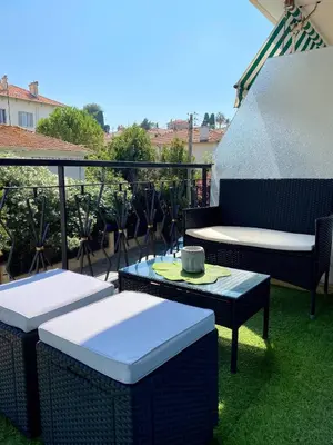 a balcony with two chairs and a table with a hat on it at Magnifique appartement le Cannet,Cannes, Parking, Wifi in Le Cannet