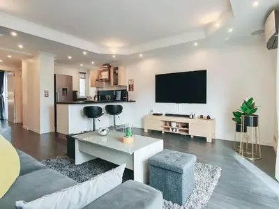 a living room with a couch and a tv on a wall at Magnifique appartement le Cannet,Cannes, Parking, Wifi in Le Cannet