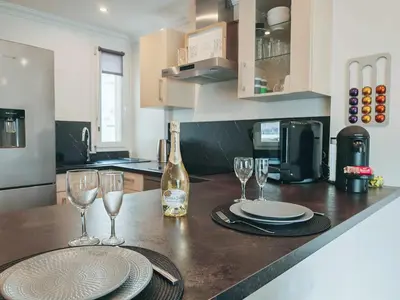 a kitchen with a table with glasses and a bottle of wine at Magnifique appartement le Cannet,Cannes, Parking, Wifi in Le Cannet