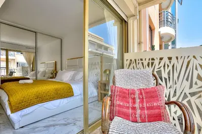 a bedroom with a bed and a chair at Luxury 4 Stars Apartment with 2 Terraces, Cannes Croisette in Cannes